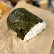 ser-goldschmidt-z-czosnkiem-i-oliwkami-w lisciach-winogron.webp